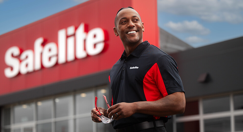 Photo of a Safelite employee standing in front of a Safelite store.