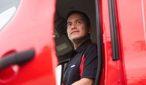 Técnico de Safelite visto a través de la puerta abierta de un vehículo taller de vidrios móvil